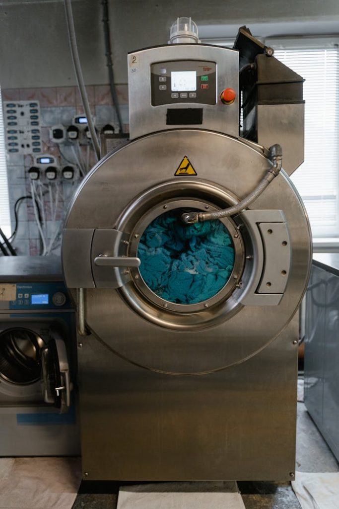 Hello world! A close-up view of an industrial washing machine in a modern laundry facility.